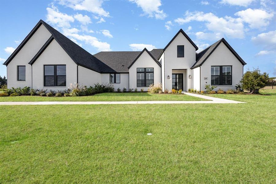 Modern farmhouse style home with a front lawn