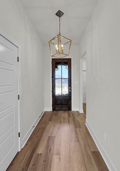 Foyer featuring wood finished floors and a chandelier