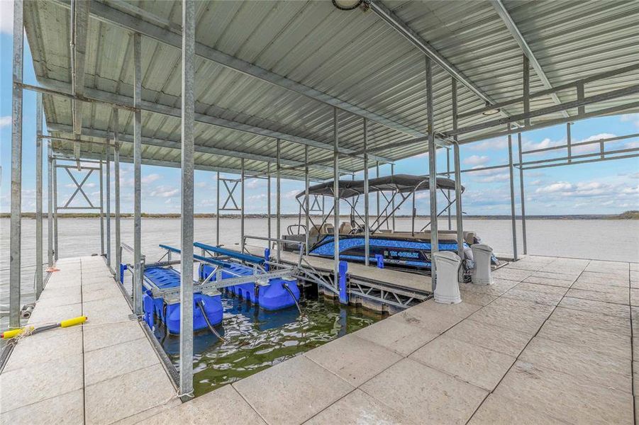 Dock featuring boat lift and a water view