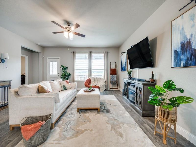 Wood-look tile flooring adds warmth and style, while large windows fill the space with natural light.