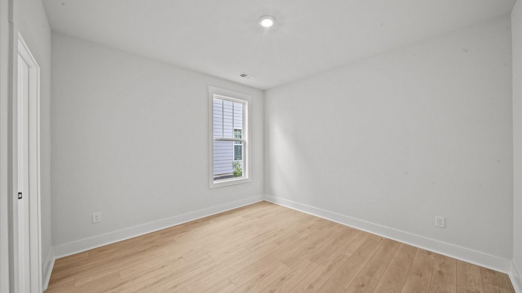 Functional secondary bedrooms with hardwood flooring and modern touches in an exceptional layout