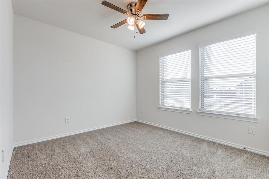 Carpeted spare room featuring ceiling fan