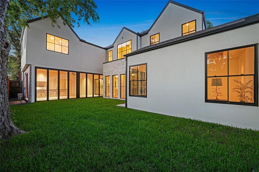 Expansive green lawn bordering a contemporary white stucco exterior