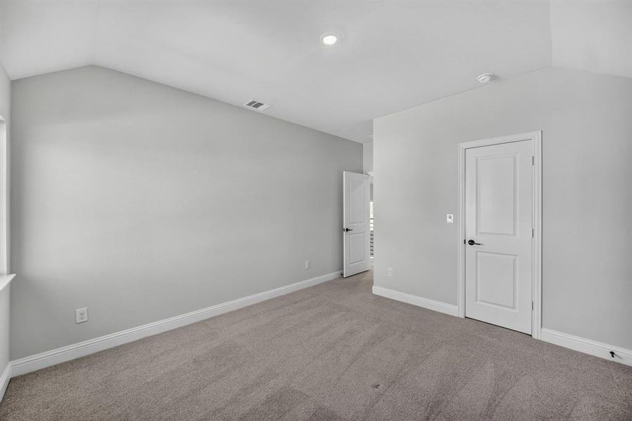 Room featuring vaulted ceilings, light gray wall color, neutral carpet flooring, white trim, and a recessed ceiling light