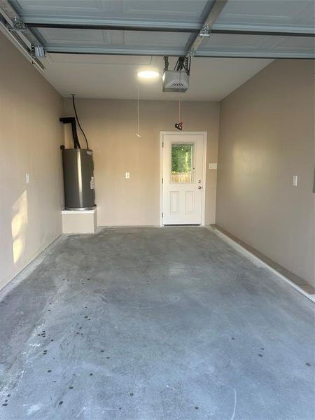 Garage featuring water heater and a garage door opener
