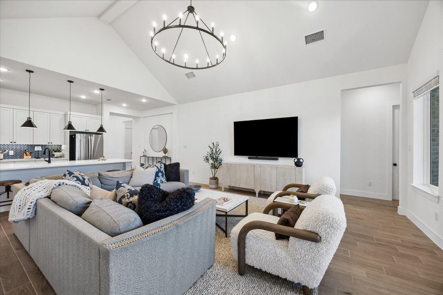 Open concept living anchored by soaring ceilings and a statement chandelier, with a seamless connection to the kitchen and dining areas. Oversized island with pendant lighting creates a natural gathering space while maintaining clean sightlines throughout. Open concept living anchored by soaring ceilings and a statement chandelier, with a seamless connection to the kitchen and dining areas. Oversized island with pendant lighting creates a natural gathering space while maintaining clean sightlines throughout.