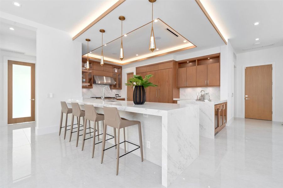 The gourmet kitchen is a chef’s dream, featuring marble countertops, real wood cabinetry,