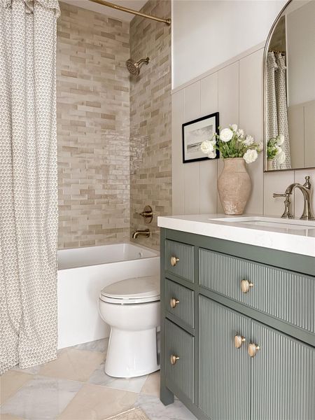 Bathroom featuring a tub and shower combination with stacked rectangular tile surround Bathroom featuring a tub and shower combination with stacked rectangular tile surround