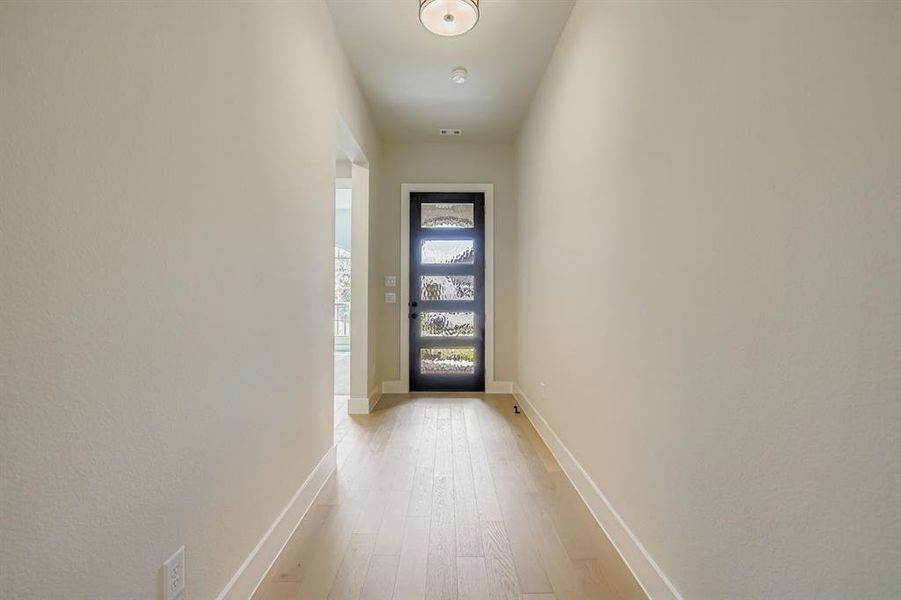 Entryway with baseboards and wood finished floors
