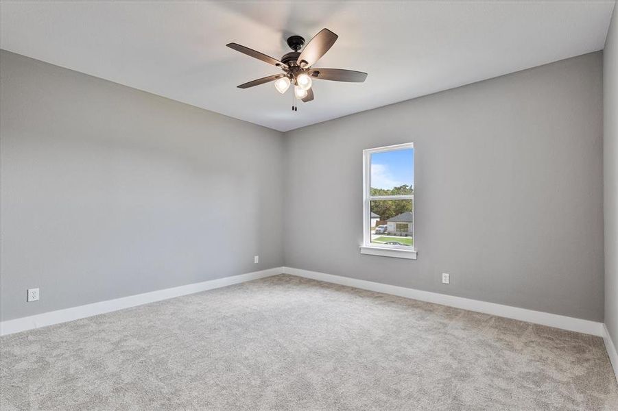 Spare room with ceiling fan and carpet floors