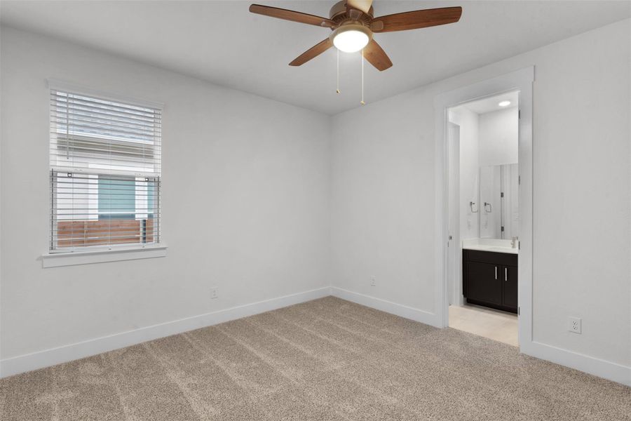 Unfurnished bedroom with light colored carpet, a ceiling fan, and ensuite bath