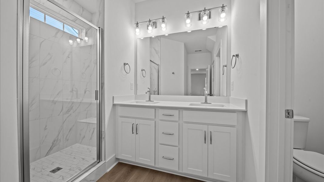 First-rate primary bathroom offering an elegant tiled walk-in shower and dual sinks with superior style