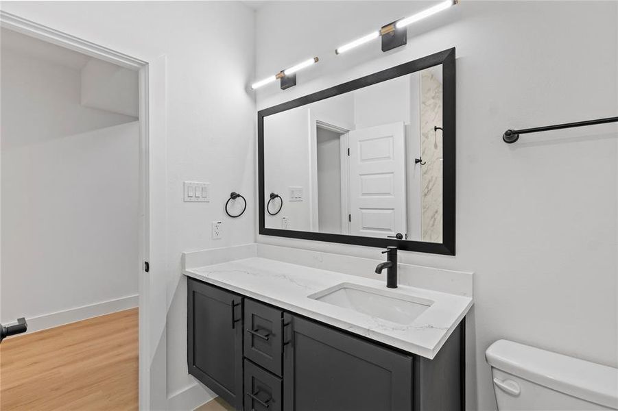 Bathroom with vanity, hardwood / wood-style flooring, and toilet