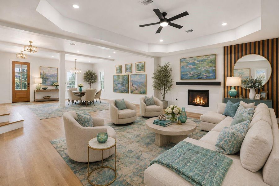 This stunning grand room is the heart of the home, offering an expansive open-concept design with soaring tray ceilings, wide plank modern flooring, and abundant natural light throughout. The sleek gas fireplace with designer accent wall creates a sophisticated focal point, while the spacious layout seamlessly connects the living and dining areas for effortless entertaining. Thoughtfully designed with upscale finishes and clean modern lines, this elegant space perfectly balances luxury, warmth, and function This stunning grand room is the heart of the home, offering an expansive open-concept design with soaring tray ceilings, wide plank modern flooring, and abundant natural light throughout. The sleek gas fireplace with designer accent wall creates a sophisticated focal point, while the spacious layout seamlessly connects the living and dining areas for effortless entertaining. Thoughtfully designed with upscale finishes and clean modern lines, this elegant space perfectly balances luxury, warmth, and function