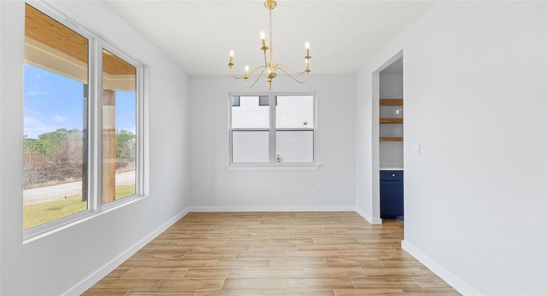Unfurnished dining area featuring a chandelier and wood tiled floors