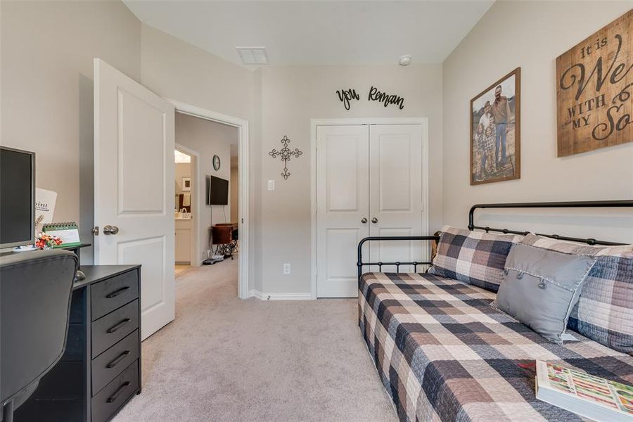 Bedroom featuring light colored carpet, a closet, and an office area