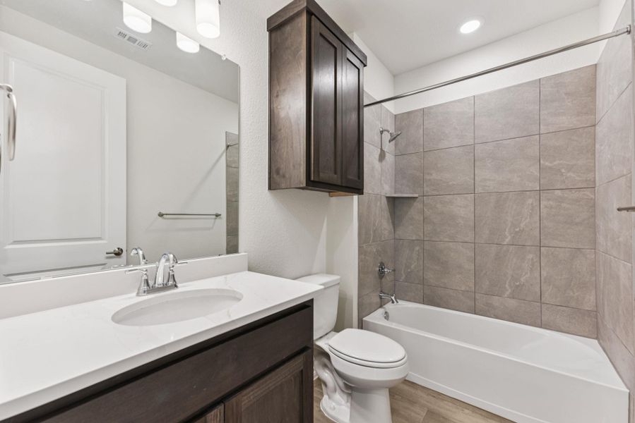 Bathroom with bathtub / shower combination, vanity, and light wood-style floors Bathroom with bathtub / shower combination, vanity, and light wood-style floors