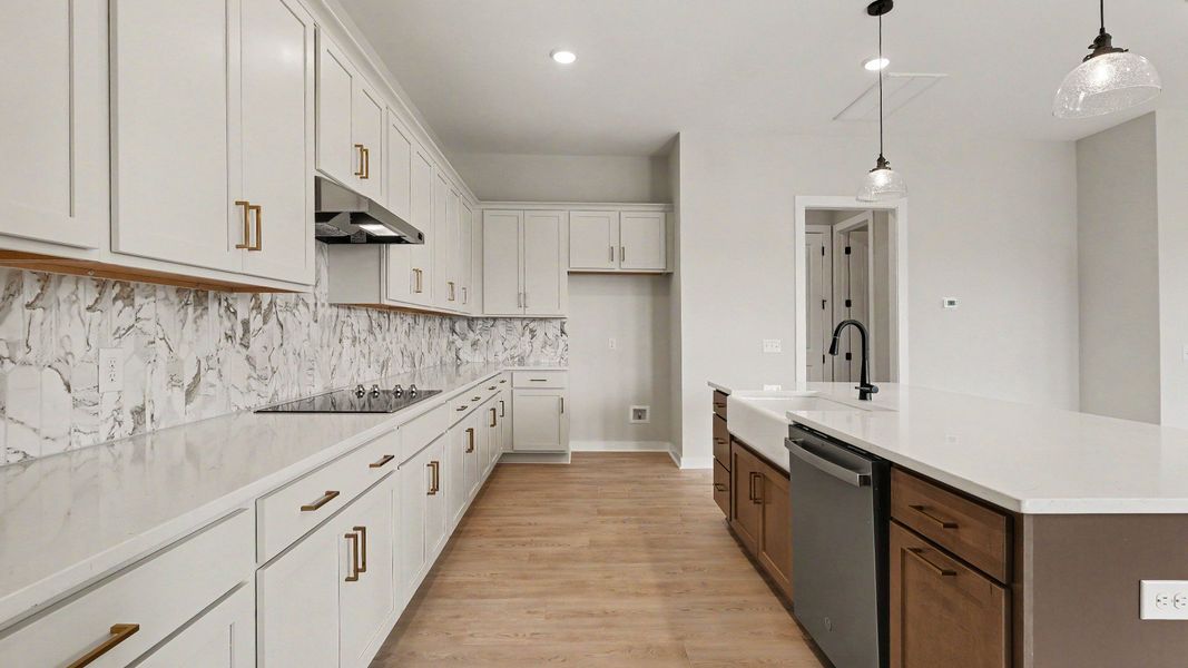 Huge kitchen with quartz countertops and accent backsplash, with a corner pantry and tons of workspace