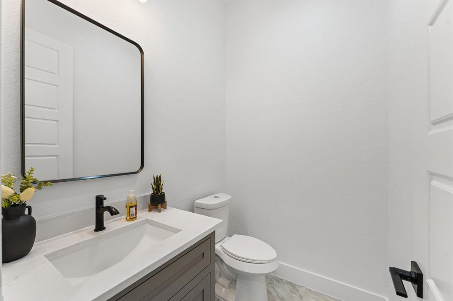 Stylish half bath conveniently located for guests with elegant fixtures and upgraded tile. Stylish half bath conveniently located for guests with elegant fixtures and upgraded tile.