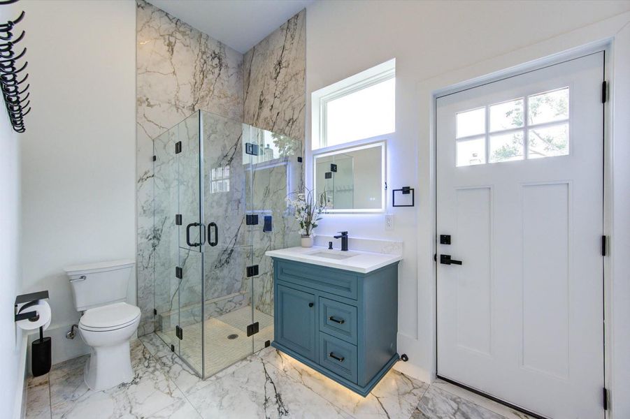 Guest bathroom with direct access to the backyard — perfect as a pool bath. Floating vanities in each bathroom.