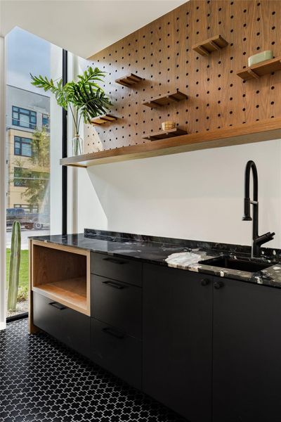 Bar area with open shelves, healthy amount of natural light, dark cabinets, modern cabinets, and a wall of windows
