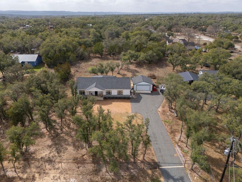 Aerial view of property and surrounding area featuring a forest