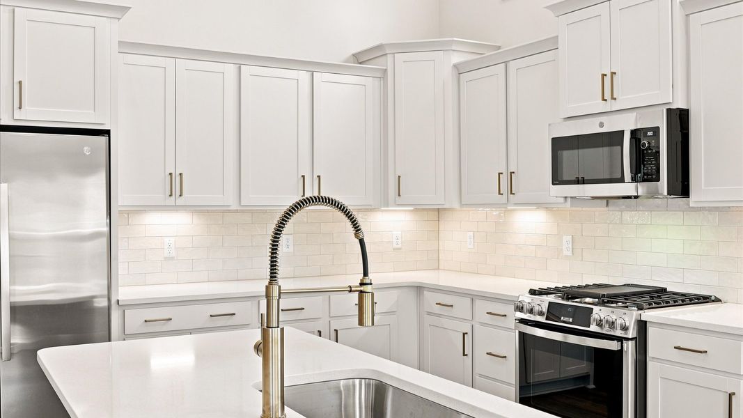 Memorable meals begin in this vibrant kitchen with quartz countertops and a thoughtfully designed island by DRB Homes
