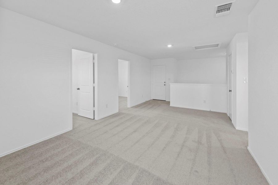Empty room with light carpet, attic access, and recessed lighting