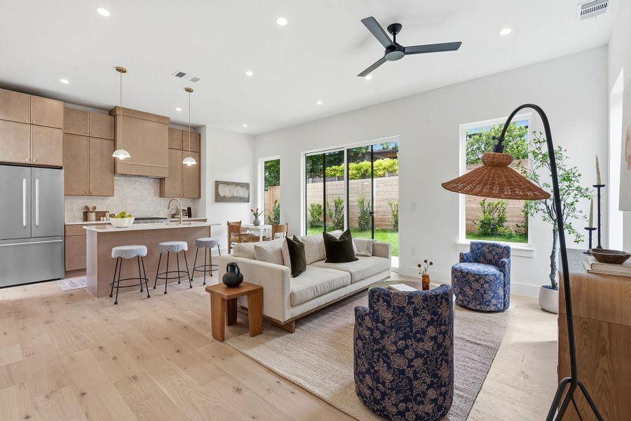 Open-concept living space featuring wood-finish flooring, recessed lighting, and a contemporary ceiling fan