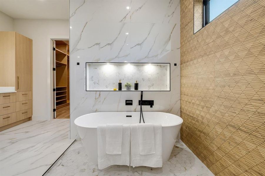 Bathroom featuring a washtub and tile walls