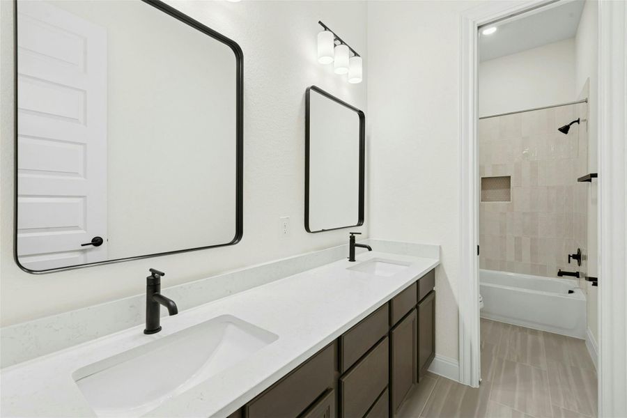 Bathroom featuring double vanity and shower / bath combination