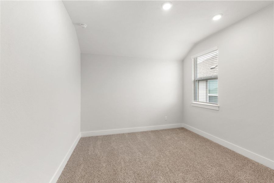 Empty room featuring light carpet, baseboards, vaulted ceiling, recessed lighting, and a smoke detector Empty room featuring light carpet, baseboards, vaulted ceiling, recessed lighting, and a smoke detector
