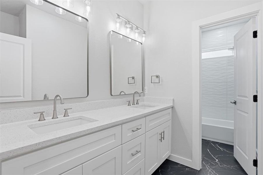 Dual vanity with white cabinetry, integrated sinks, brushed nickel fixtures, and light-toned countertops