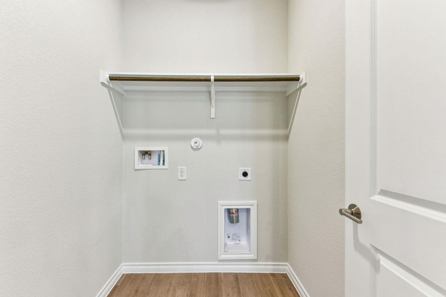 Washroom with light wood-type flooring, hookup for a gas dryer, electric dryer hookup, and washer hookup