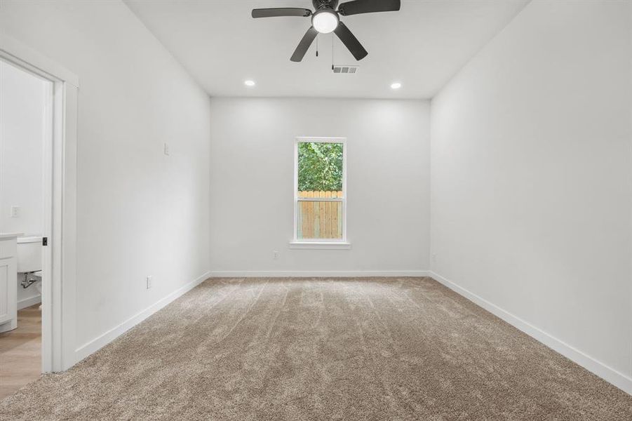 Spare room featuring light colored carpet and ceiling fan