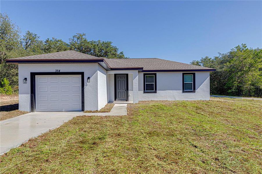 Front exterior of a new home in , Ocklawaha, FL, highlighting curb appeal (Image 1).