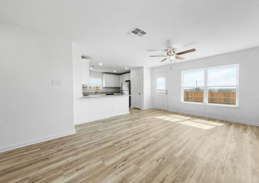 A spacious family room with a large window facing the backyard