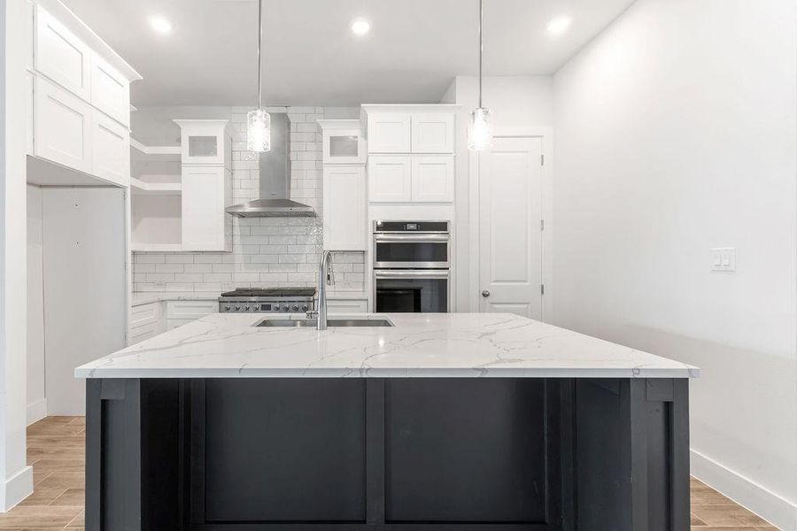 A grand central island anchors this pristine culinary space, complete with sleek appliances and ample counter area. A grand central island anchors this pristine culinary space, complete with sleek appliances and ample counter area.