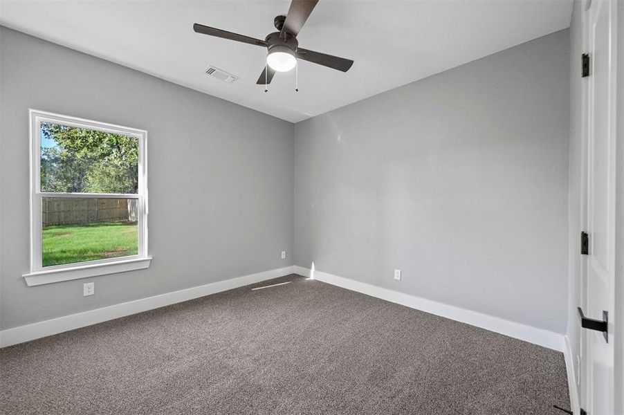 Spare room with ceiling fan and carpet floors