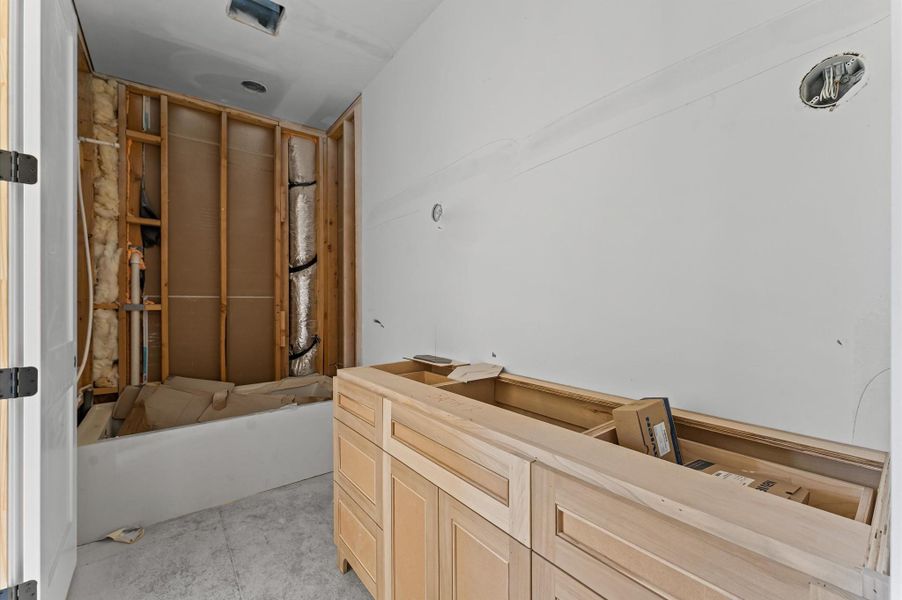 Secondary upstairs bathroom with shaker cabinets and shower/tub combo.