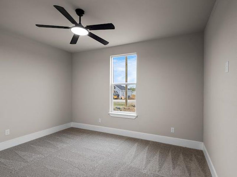 Spare room featuring light colored carpet and ceiling fan