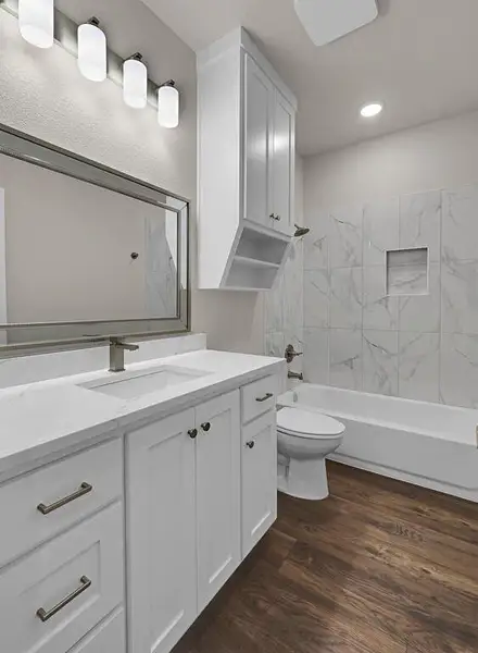 Full bathroom featuring vanity, wood finished floors, shower / washtub combination, and recessed lighting