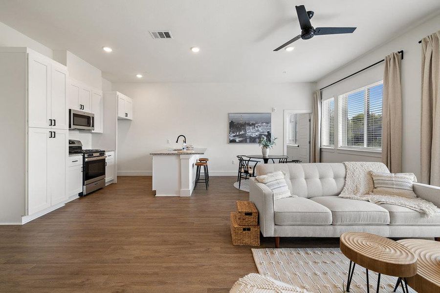 Living room with recessed lighting, dark wood-type flooring, and a ceiling fan