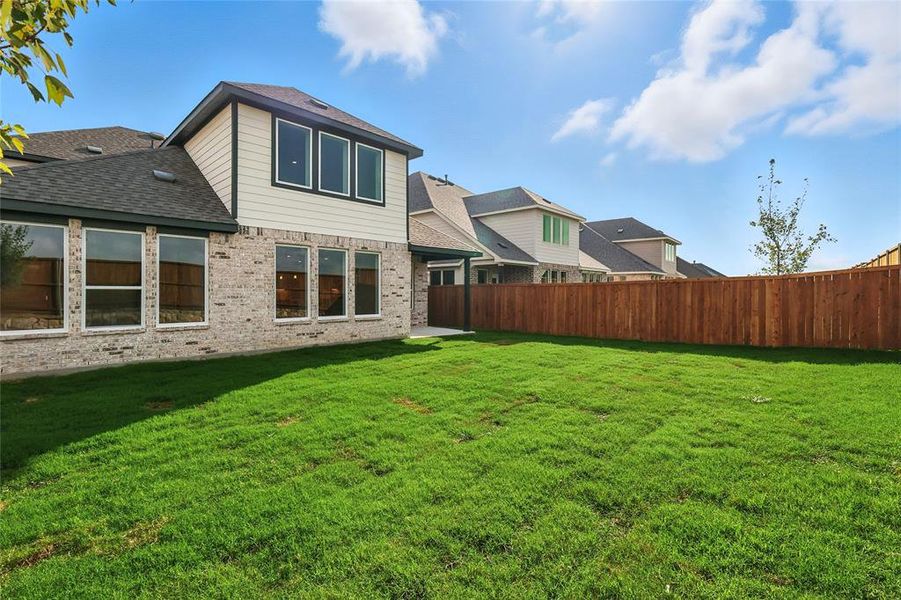 Back of property with a shingled roof, a patio, and brick siding Back of property with a shingled roof, a patio, and brick siding