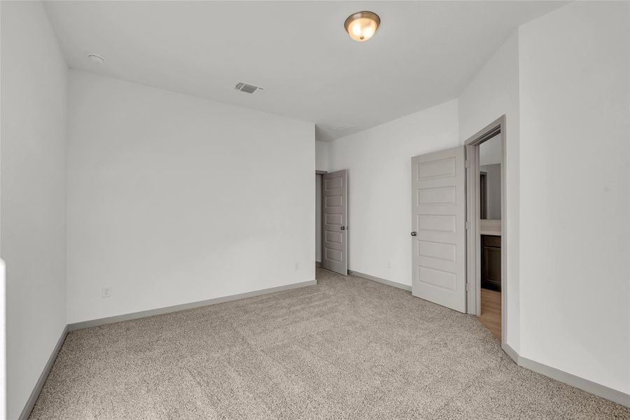 Unfurnished bedroom featuring light colored carpet and baseboards