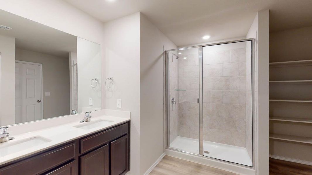 Bathroom with double vanity, light wood-style floors, a stall shower, a closet, and recessed lighting