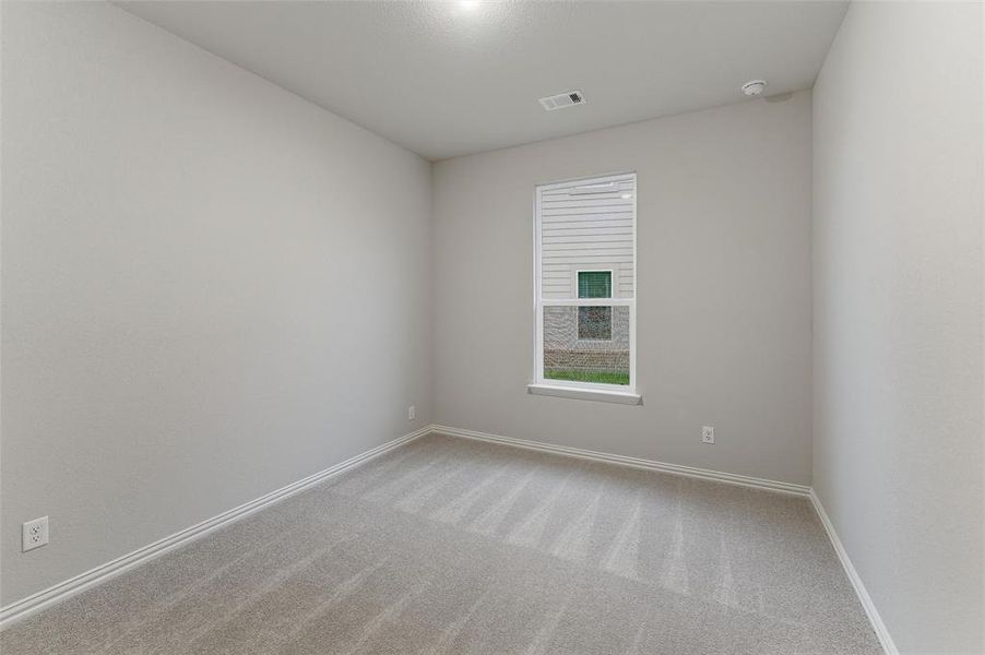 Neutral tone walls and carpeting throughout a room featuring a single window with blinds, baseboard trim, and a ceiling-mounted light fixture