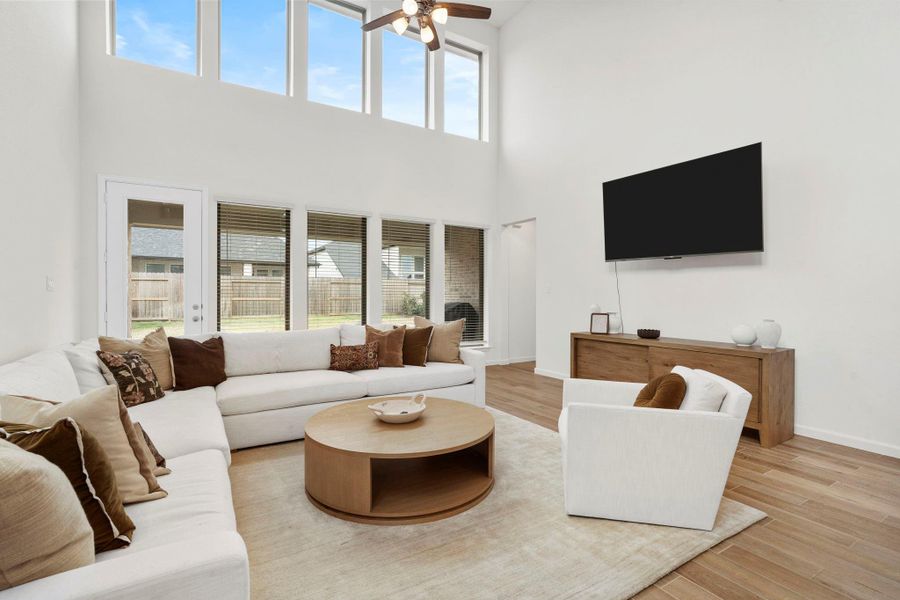 Magnificent two-story family room featuring a wall of windows that bathe the open space in natural light. Magnificent two-story family room featuring a wall of windows that bathe the open space in natural light.