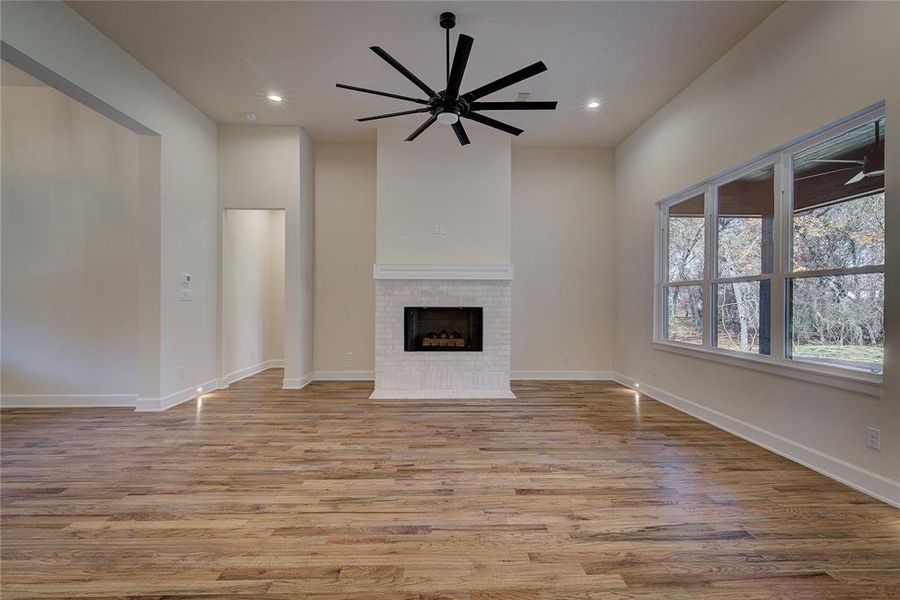 Gas log fireplace, gorgeous red oak floors, and a wall of windows make the living room a statement.
