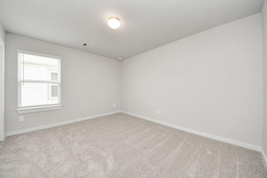 Secondary bedroom features plush carpeting, large windows that let in plenty of natural light, bright paint, and spacious closets. Sample photo of completed home with similar floor plan. Actual colors and selections may vary. Secondary bedroom features plush carpeting, large windows that let in plenty of natural light, bright paint, and spacious closets. Sample photo of completed home with similar floor plan. Actual colors and selections may vary.